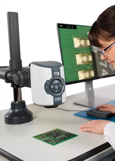 Operator przy stanowisku z&nbsp;mikroskopem EVO Cam II Vision Engineering i&nbsp;monitorem podglądu