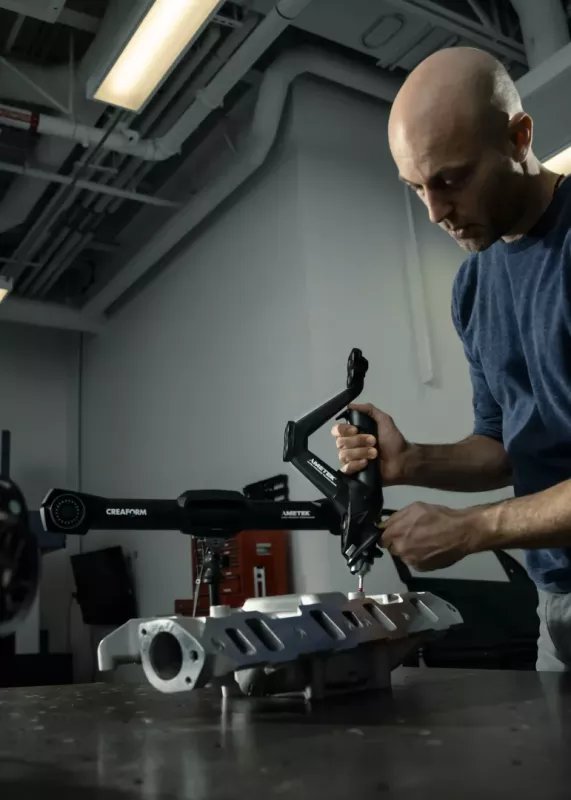 Operator mierzący odlew kolektora dolotowego V8 za pomocą HandyPROBE NEXT z systemem MetraSCAN 3D