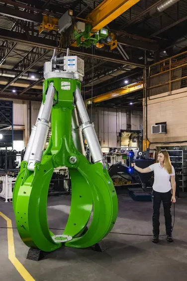 Operator skanerem 3D HandySCAN 3D MAX mierzy duży zielony chwytak Rotobec na hali produkcyjnej – szybkie, precyzyjne pomiary dużych obiektów