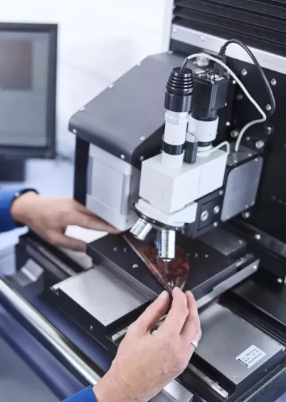 Zbliżenie: operator wykonuje pomiar twardości próbki na nanotwardościomierzu PICODENTOR HM500