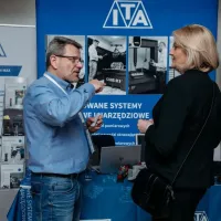 Rozmowa przedstawiciela ITA z&nbsp;uczestniczką przy stoisku – prezentacja systemów pomiarowych.