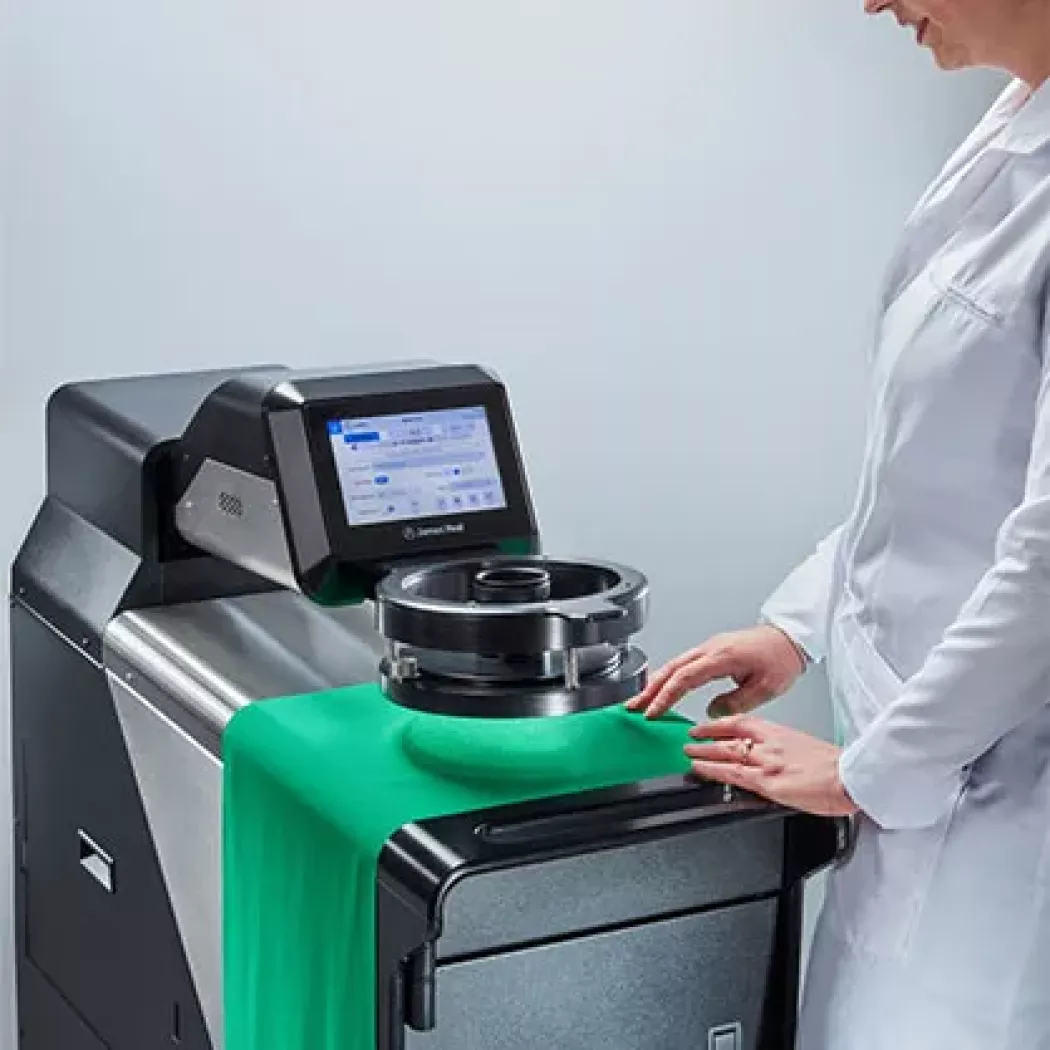 Operator przygotowuje próbkę tkaniny do pomiaru na urządzeniu AirPro James Heal