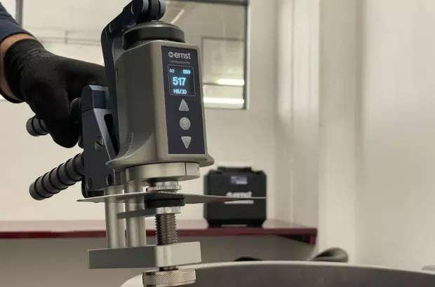 Przenośny twardościomierz Rockwella Ernst Computest Lite podczas badania twardości elementu stalowego; na ekranie widoczny odczyt.