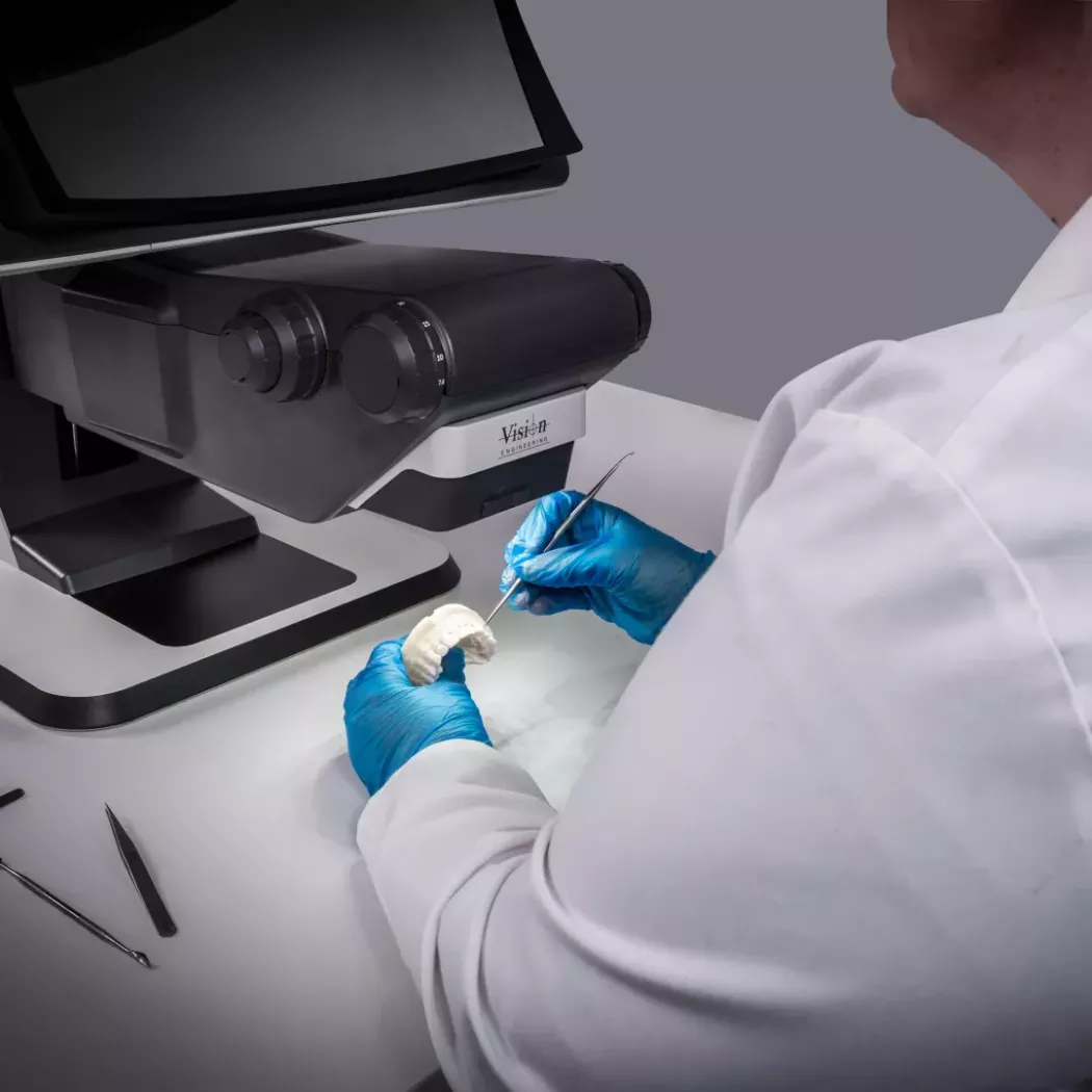 Technik protetyczny pod mikroskopem 3D FHD DRV-Z1 wykonuje dokładną obróbkę modelu zębowego