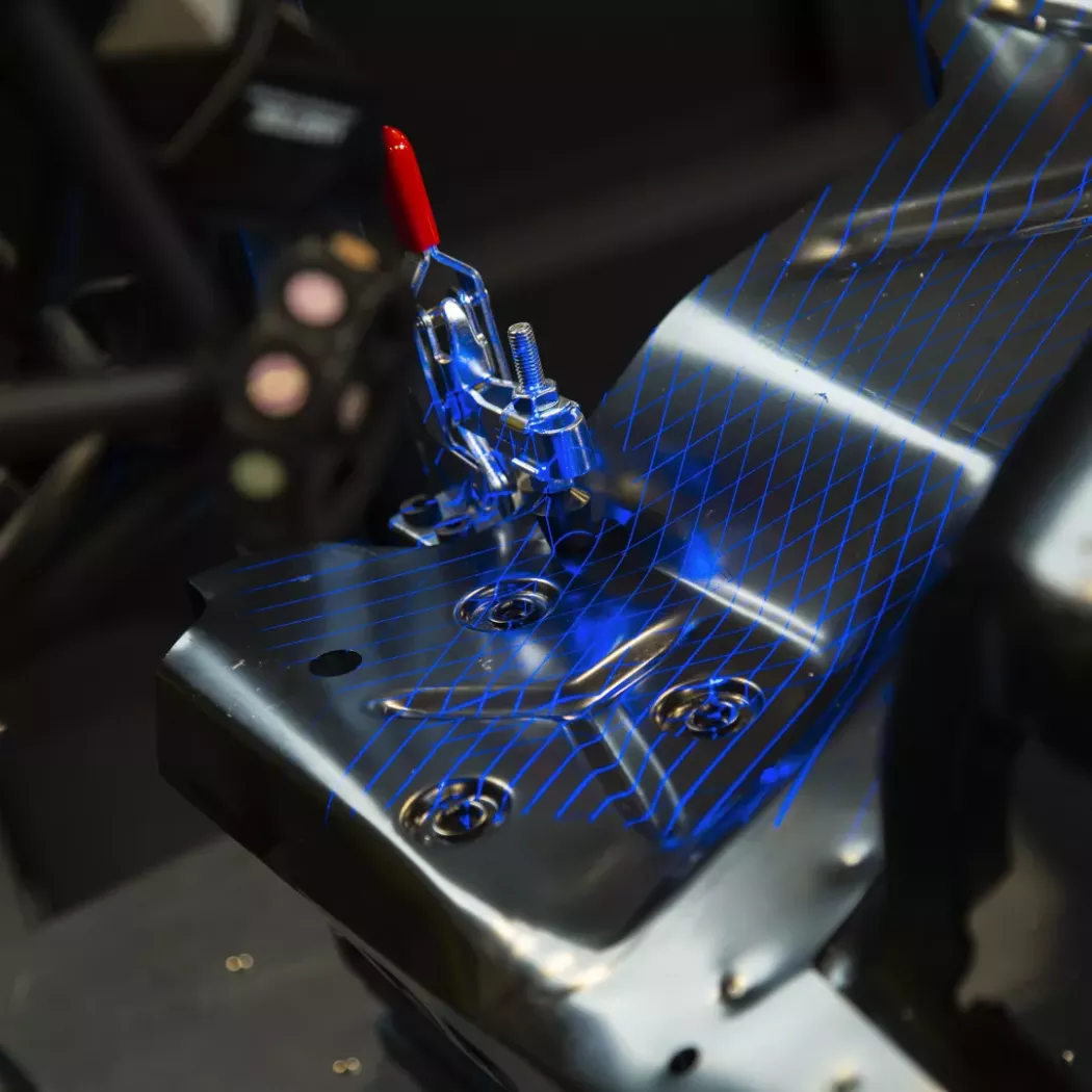 Niebieska siatka laserowa systemu MetraSCAN na powierzchni metalowej części