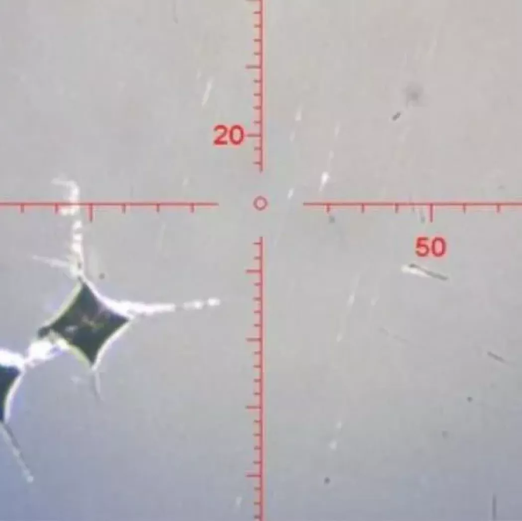 Widok pod mikroskopem: odciski wg metody Vickersa na próbce do pomiaru mikrotwardości