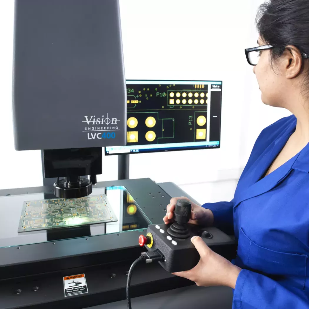 Optyczny system pomiarowy LVC 400 Vision Engineering używany do kontroli i&nbsp;pomiaru płytek drukowanych PCB przez operatorkę