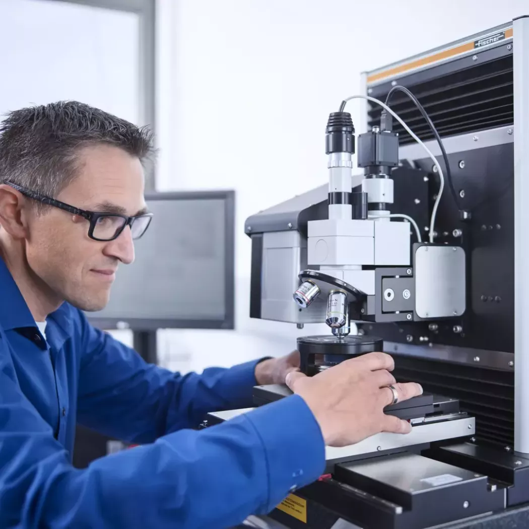 Operator ustawia próbkę na stole pomiarowym PICODENTOR HM500 przed badaniem twardości