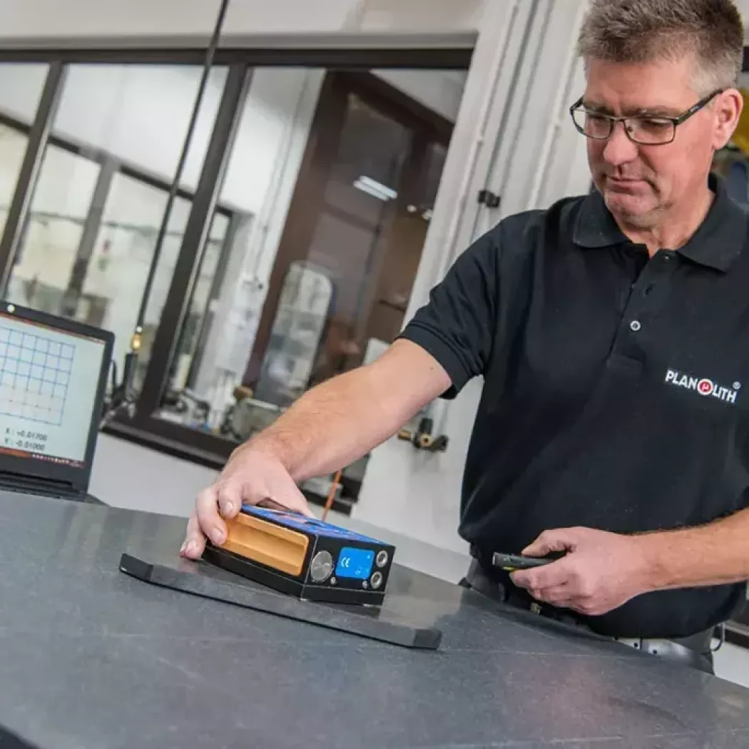 Technik Planolith mierzy płaskość płyty pomiarowej na stanowisku z rejestracją komputerową