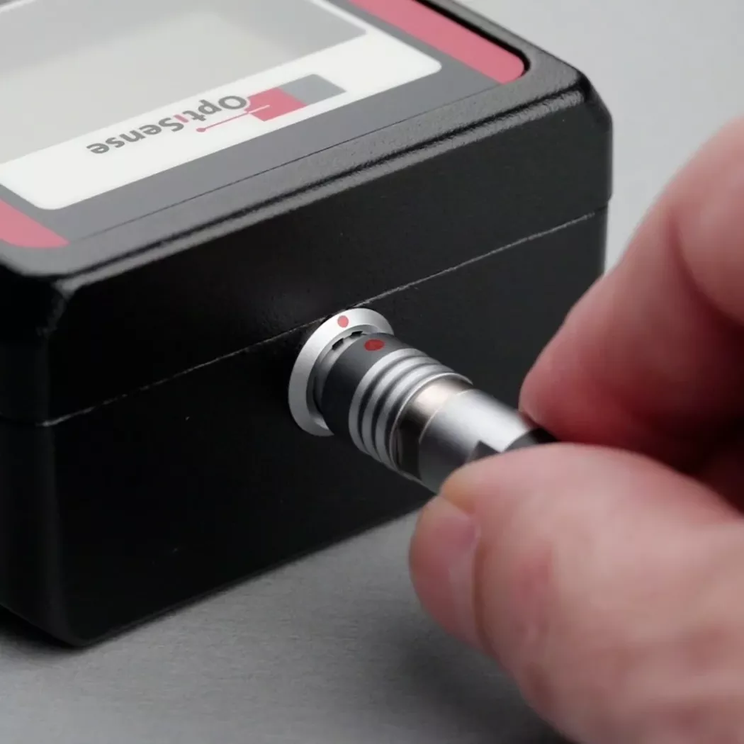 Użytkownik podłącza przewód głowicy pomiarowej do miernika OptiSense PaintChecker Mobile