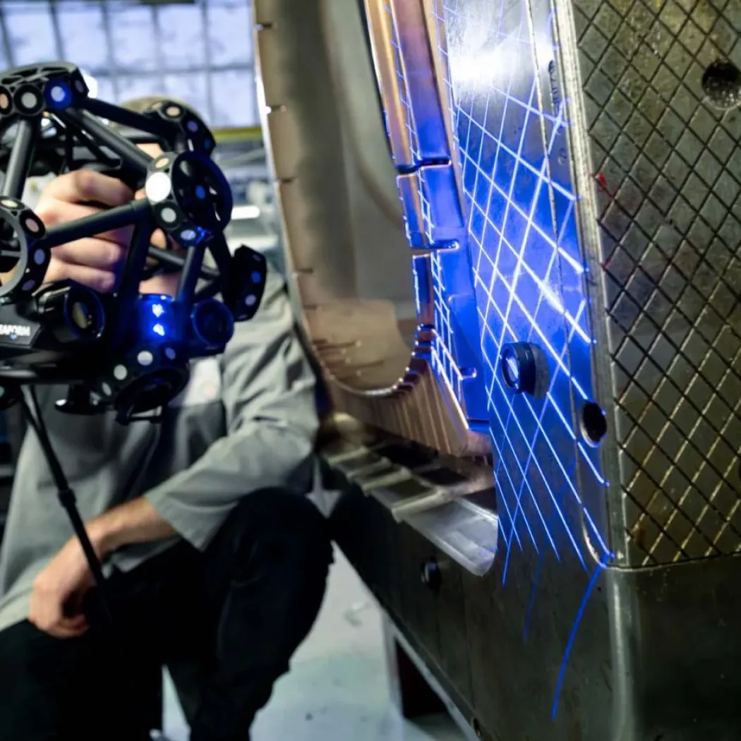 Ręczny skaner 3D MetraSCAN BLACK z&nbsp;niebieskim światłem laserowym skanuje dużą formę w&nbsp;procesie kontroli jakości